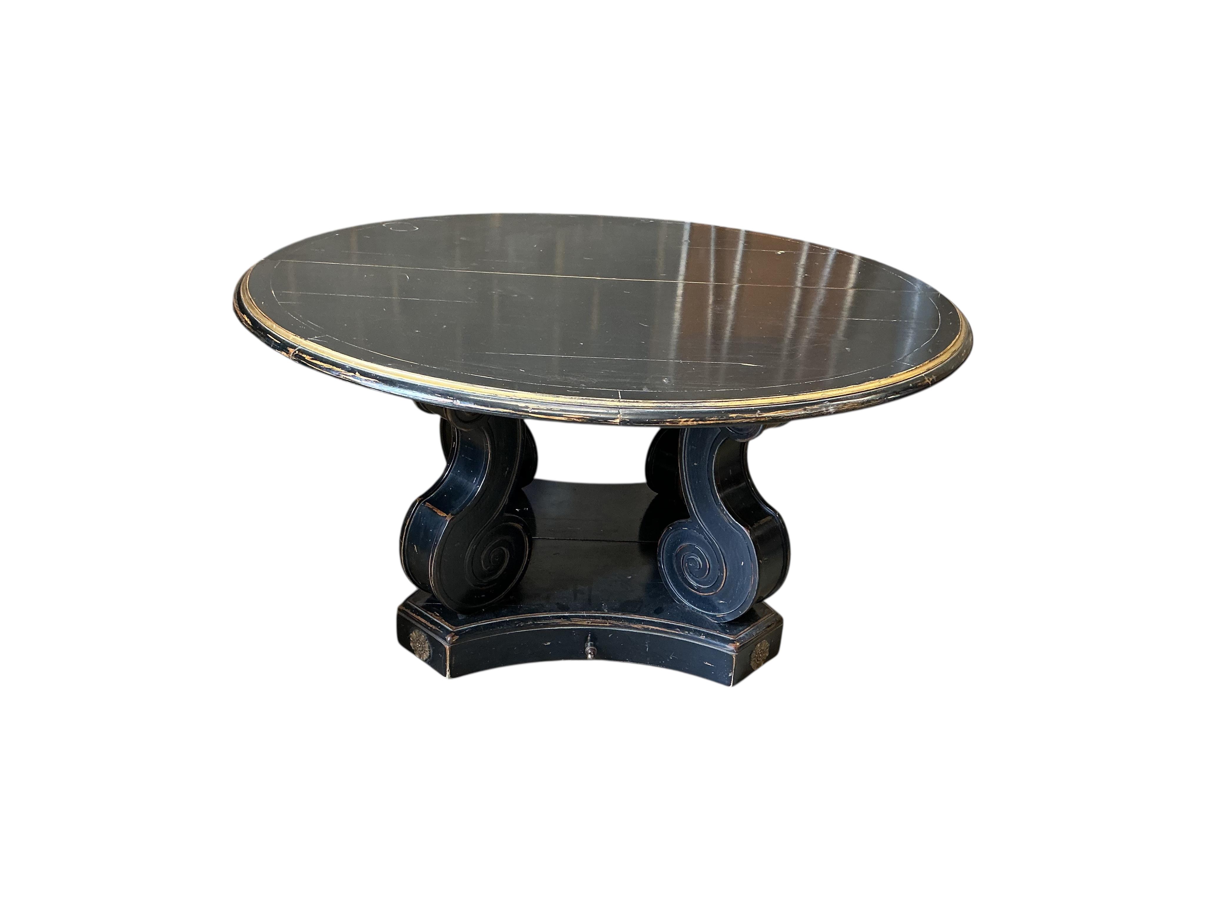 A Regency style ebonised, parcel gilt extending dining table, purchased from Liberty, diameter 150cm, 305cm extended three spare leaves, height